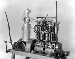 Erster Vierzylinder-Benzinmotor, ein Bootsmotor. Das erste Exemplar liefert die Daimler-Motoren-Gesellschaft am 21. August 1890 nach New York aus. Konstruiert hat ihn Wilhelm Maybach. Zu den technischen Details gehören unter anderem eine dreifach gelagerte und vierfach gekröpfte Kurbelwelle, die Ventilsteuerung über eine Nockenwelle, hängende Auslassventile sowie eine effektive Zylinderkühlung über Wassermäntel. First four-cylinder petrol engine, a marine engine. Daimler-Motoren-Gesellschaft delivered the first of these cars to New York on 21 August 1890. It had been designed by Wilhelm Maybach. The technical refinements included a three-bearing, four-throw crankshaft, valve train via a camshaft, overhead exhaust valves and effective cylinder cooling using water jackets.