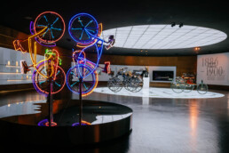 Raum Mythos 1: Pioniere – die Erfindung des Automobils, 1886 bis 1900, mit dem Werk von Robert Rauschenberg, „Riding Bikes“, 1998. Sonderausstellung „Moving in Stereo“, Highlights der Mercedes-Benz Art Collection, 27. Oktober 2022 bis 11. Juni 2023. Die Ausstellung im Mercedes-Benz Museum zeigt 150 Arbeiten von 90 internationalen und nationalen Künstlerinnen und Künstlern aus 20 Ländern. Bildnachweis: Robert Rauschenberg, „Riding Bikes“, 1998, © VG Bild-Kunst Bonn, 2022. Die Verwendung des Fotos ist im Rahmen einer redaktionellen Berichterstattung über die oben genannte Ausstellung „Moving in Stereo“ gestattet.