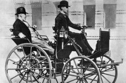 Gottlieb Daimler lässt sich im Fond seiner „Motorkutsche“ aus dem Jahr 1886 von seinem Sohn Adolf chauffieren. (Fotosignatur der Archive von Mercedes-Benz Classic: C23227) // Gottlieb Daimler in the rear of his “motorised carriage” from the year 1886 has his son chauffeur him. (Photo index number in the Mercedes-Benz Classic Archives: C23227)