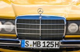 Mercedes-Benz 230 der Baureihe 123. Detailaufnahme von vorn mit ikonischem Mercedes-Grill. (Fotosignatur der Mercedes-Benz Classic Archive: D290784)