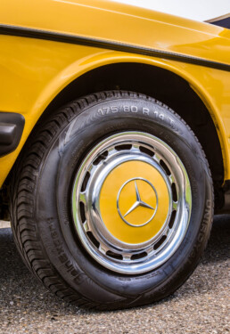 Mercedes-Benz 230 der Baureihe 123. Detailaufnahme des linken Vorderrads mit klassischer Radkappe. (Fotosignatur der Mercedes-Benz Classic Archive: D290454)