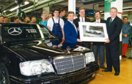 Hans Herrmann, Mercedes-Benz Werksrennfahrer in den Jahren 1954 und 1955. Am 10. Oktober 1994 nimmt Herrmann als Kunde den zehntausendsten Mercedes-Benz E 500 (W 124) in Empfang. Überreicht wird die Hochleistungslimousine im Porsche-Werk Zuffenhausen, wo das Fahrzeug montiert wird. (Fotosignatur der Mercedes-Benz Classic Archive: 00075728)