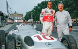 Hans Herrmann, Mercedes-Benz Werksrennfahrer in den Jahren 1954 und 1955. Foto am Formel 1-Rennwagen W 196 R mit Formel 1-Rennfahrer Lewis Hamilton bei der Mercedes-Benz Fashion Week Berlin, Power meets Fashion, 12. Juli 2007. (Fotosignatur der Mercedes-Benz Classic Archive: 07A1624)