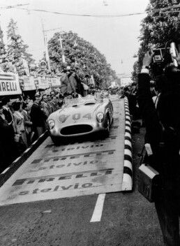 Hans Herrmann, Mercedes-Benz Werksrennfahrer 1954 und 1955. Foto vom Start der Mille Miglia 1955 in Brescia mit Beifahrer Hermann Eger im Mercedes-Benz 300 SLR Rennsportwagen mit der Startnummer 704. (Fotosignatur der Archive von Mercedes-Benz Classic: R7228)