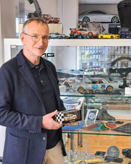 Volker Weidler, ehemaliger Mercedes-Benz Rennfahrer und DTM-Vizemeister 1986 mit einem Modell seines Mercedes-Benz 190 E 2.3-16 bei Mercedes-AMG in Affalterbach. Foto aus dem Jahr 2024. Foto: Michael Petersen.