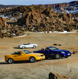 Mercedes-Benz SLK 200 in der Lackierung yellowstone (vorn) und SLK 230 Kompressor der Baureihe R 170, im Hintergrund ein Mercedes-Benz 190 SL (W 121). Genreaufnahme aus dem Jahr 1996. (Fotosignatur der Archive von Mercedes-Benz Classic: A96F1312)