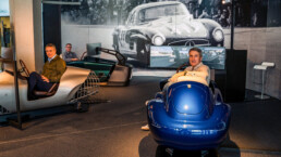 Spaß beim virtuellen Wettbewerb: die Rennfahrer und Mercedes-Benz Classic Markenbotschafter Karl Wendlinger, Bernd Mayländer und Bernd Schneider (von links nach rechts) in den Highend-Fahrsimulatoren im Mercedes-Benz Museum. Foto vom März 2026. Foto: JF Films. (Fotosignatur der Archive von Mercedes-Benz Classic: D881204)