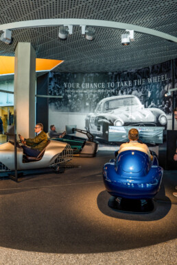 Spaß beim virtuellen Wettbewerb: die Rennfahrer und Mercedes-Benz Classic Markenbotschafter Karl Wendlinger, Bernd Mayländer und Bernd Schneider (von links nach rechts) in den Highend-Fahrsimulatoren im Mercedes-Benz Museum. Foto vom März 2026. Foto: JF Films. (Fotosignatur der Archive von Mercedes-Benz Classic: D881191)