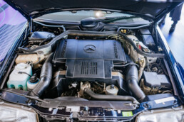 Mercedes-Benz E 500 Limited (Baureihe 124) aus dem Jahr 1995 in der Sonderausstellung „Youngtimer“ des Mercedes-Benz Museums. Foto des Motorraums mit dem V8-Motor M 119. Foto: Thomas Niedermüller. (Fotosignatur der Archive von Mercedes-Benz Classic: D87893
