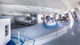 Mercedes-Benz Museum, Sonderausstellung „130 Jahre Nutzfahrzeuge“. Übersichtsaufnahme. Von links nach rechts: Mercedes-Benz eSprinter (2024), Mercedes-Benz eActros 600 (2024), Mercedes-Benz O 319 D Panoramabus (1961), Mercedes-Benz L 911 Kurzhauber-Lkw (1966), Mercedes-Benz 170 V Servicefahrzeug (1952) und Benz 1C (1922). Foto: Dirk Weyhenmeyer.