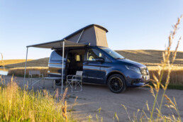 Der neue Mercedes-Benz Marco Polo gefertigt im Mercedes-Benz Werk in Ludwigsfelde – Sodalithblau metallic, MBUX Multimediasystem, Widescreen Cockpit, Polster Leder Lugano schwarz, Camper-Umfänge u.a. Markise, Kleiderschrank, Küchenzeile mit Klapptisch, Drehbare Fahrer- und Beifahrersitze, Sitzliegebank, Aufstelldach mit Dachbett, MBAC Camper-Bedieneinheit (Ausgewählte Features erst im Jahresverlauf 2026 erhältlich; Landesspezifische Vorschriften zum Wildcampen sind zu beachten, Aufnahmen auf Privatgrundstücken entstanden)