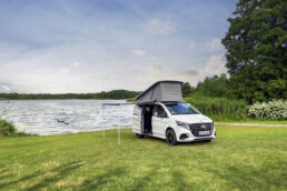 Der neue Mercedes-Benz Marco Polo HORIZON gefertigt im Mercedes-Benz Werk in Ludwigsfelde – Bergkristallweiß metallic, MBUX Multimediasystem, Widescreen Cockpit, Polster Leder Lugano schwarz, Camper-Umfänge u.a. Markise, Drehbare Fahrer- und Beifahrersitze, Sitzliegebank, Aufstelldach mit Dachbett (Ausgewählte Features erst im Jahresverlauf 2026 erhältlich; Landesspezifische Vorschriften zum Wildcampen sind zu beachten; Aufnahmen auf Privatgrundstücken entstanden)