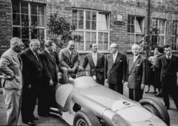 Alfred Neubauer, Mercedes-Benz Rennleiter von 1926 bis 1955 (2. von links). Abschlussfeier der Rennsaison 1955 im Mercedes-Benz Werk Untertürkheim am 24. Oktober 1955. Von links nach rechts am Mercedes-Benz Formel-1-Rennwagen W 196 R: Piero Taruffi, Rennleiter Alfred Neubauer, Werner Engel, Karl Kling (halb verdeckt), Juan Manuel Fangio, Stirling Moss, Dr. Hermann Veit (Wirtschaftsminister von Baden-Württemberg), Fritz Nallinger und André Simon. (Fotosignatur der Archive von Mercedes-Benz Classic: 55299-18)